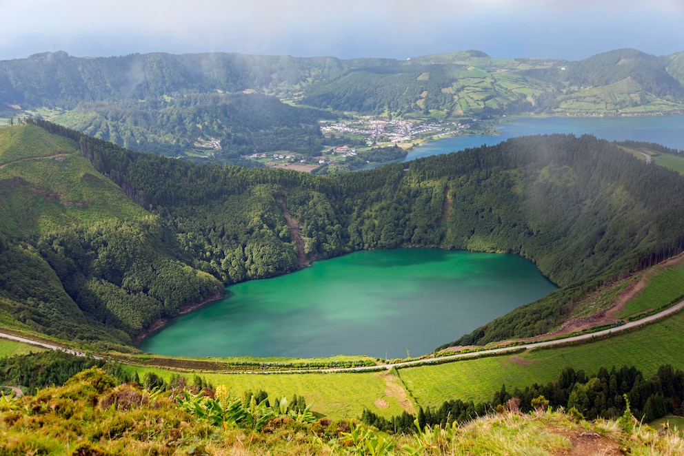 Der Lagoa das Sete Cidades ist ein See in einem Krater auf der größten Azoreninsel São Miguel. Mit einer Fläche von 4,37 Quadratkilometern ist er der größte See der Azoren. Er entstand nach einer Serie von Vulkanausbrüchen, bei denen der Vulkankegel des 1200 Meter hohen Vulkans zerstört wurde und sich schließlich ein Krater bildete. Bestehend aus zwei Teilseen enthält er nahezu die Hälfte der Süßwasserressourcen der Inseln. Der größere See trägt den Namen Lagoa Azul (Blauer See) und der kleinere Lagoa Verde (Grüner See). Verbunden sind beide Seen durch einen schmalen Kanal. Blickt man vom Rand des Vulkankraters auf den Lagoa Verde, schimmert dieser aufgrund des umliegenden Nadelwaldes grün. Das Wasser im Lagoa Azul leuchtet wiederum Blau.&nbsp;