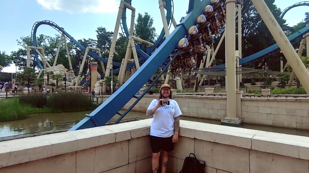 Fabian im Freizeitpark Parc Asterix in Frankreich, nachdem er erfolgreich die „Oziris“ (im Hintergrund zu sehen) gefahren ist – seine 200. Achterbahn