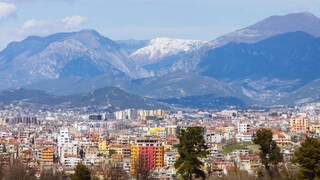 Albaniens quirlige Hauptstadt Tirana hebt sich mit ihrer bunten Farbpalette von den dahinter liegenden Bergen ab
