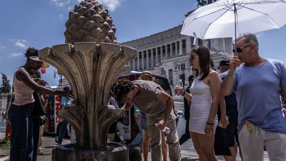 Touristen in der sengenden Sonne auf der Piazza Venezia in Rom