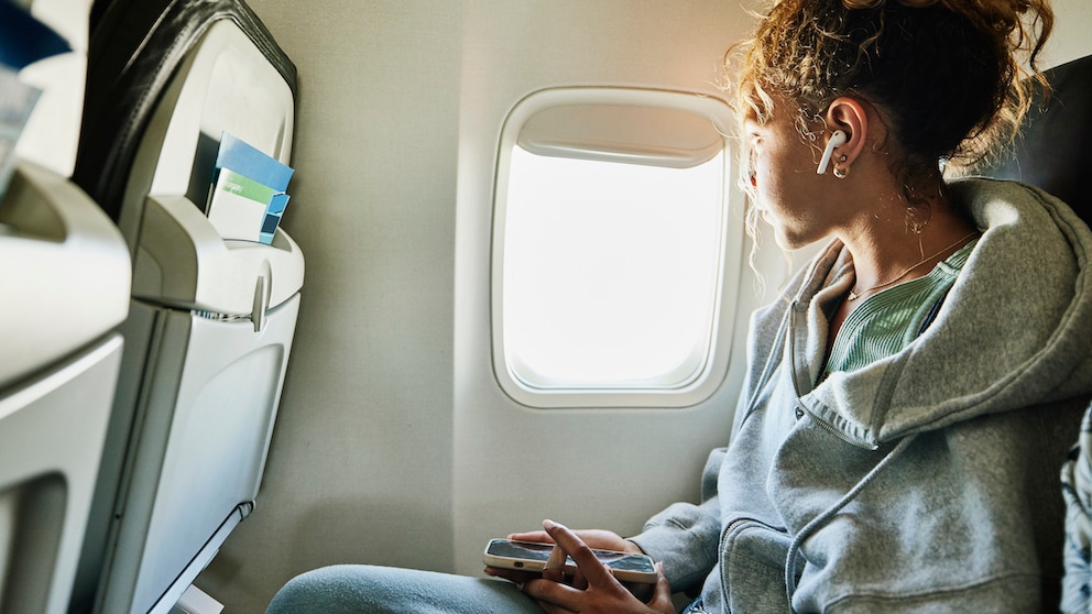 Mädchen auf Fensterplatz im Flugzeug