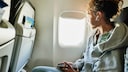 Mädchen auf Fensterplatz im Flugzeug
