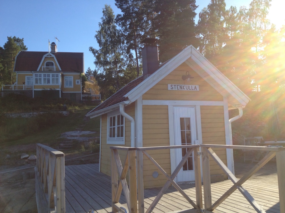 Auf dem Steg am See steht die Sauna, darüber thront mit bester Aussicht die Villa Stenkulla