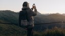 Handynutzung in der Schweiz: Tourist fotografiert Bergpanorama