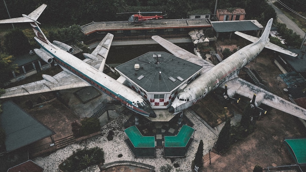 Das verlassene Flugzeug-Restaurant in Italien aus der Luft aufgenommen: Zwei Flugzeuge stehen an einem Kontroll-Tower, im Hintergrund ist ein Hubschrauber zu sehen. Foto: Ludwig P. Bäßler / Instagram loopingludi