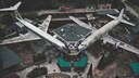 Das verlassene Flugzeug-Restaurant in Italien aus der Luft aufgenommen: Zwei Flugzeuge stehen an einem Kontroll-Tower, im Hintergrund ist ein Hubschrauber zu sehen. Foto: Ludwig P. Bäßler / Instagram loopingludi