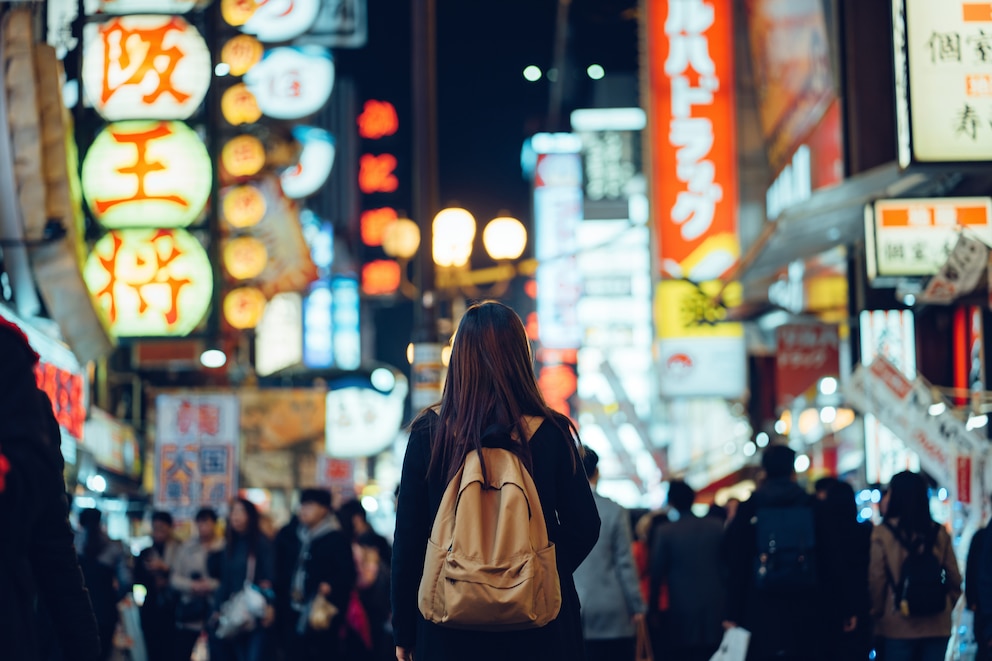 Touristin erkundet das Nachtleben in Osaka, Japan