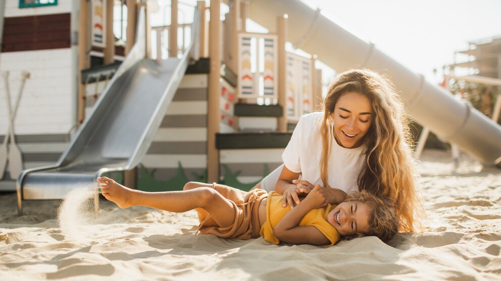 Mutter mit Kind auf Spielplatz