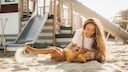 Mutter mit Kind auf Spielplatz