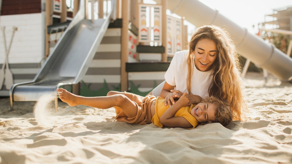 Mutter mit Kind auf Spielplatz