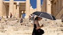 Eine Touristin sucht Schatten unter einem Schirm während ihres Besuchs auf der Akropolis. Griechenland ist in diesem Jahr besonders früh von großer Hitze in Europa betroffen.