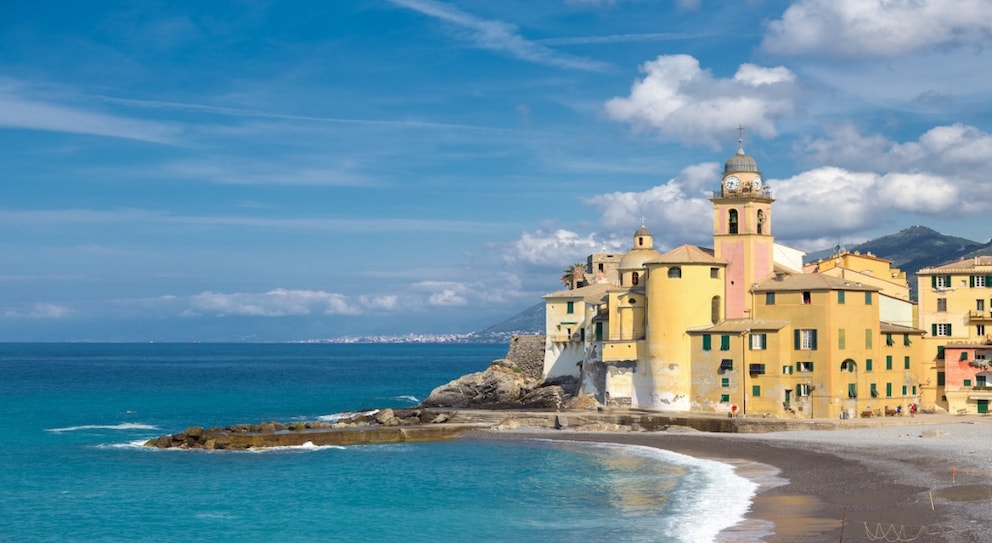 one of the most beautiful beaches in Liguria is the Spiaggia di Camogli with the Basilica di Santa Maria Assunta in the background