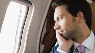Mann schaut aus einem Flugzeugfenster