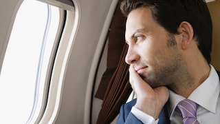 Mann schaut aus einem Flugzeugfenster