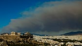 Angst vor Waldbränden als Storno-Grund? Nur wenige Kilometer nordöstlich der griechischen Hauptstadt Athen bekämpft die Feuerwehr auf einer Fläche von rund 200 Quadratkilometern unzählige Brandherde