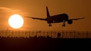 Flugzeug fliegt bei Sonnenuntergang