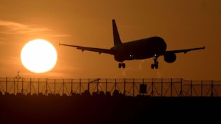 Flugzeug fliegt bei Sonnenuntergang