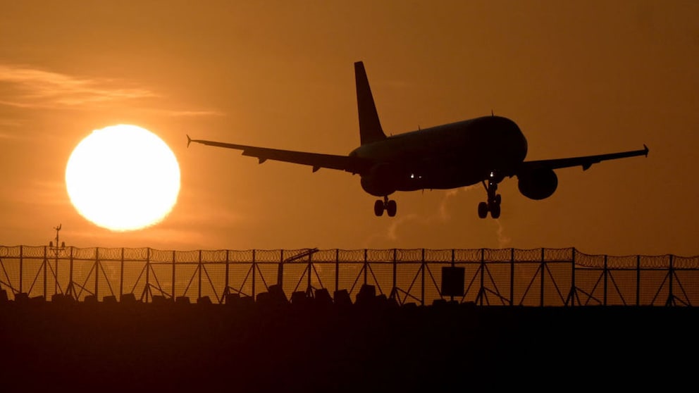 Flugzeug fliegt bei Sonnenuntergang