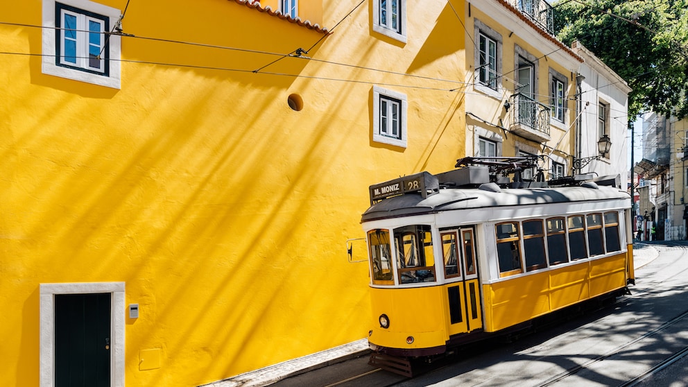 Gelbe Tram vor gelber Wand: Wir zeigen die besten Reisetipps für einen Trip nach Lissabon