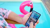 TRAVELBOOK im TV: Mann sitzt am Pool und hält Smartphone, auf dem Website zu sehen ist