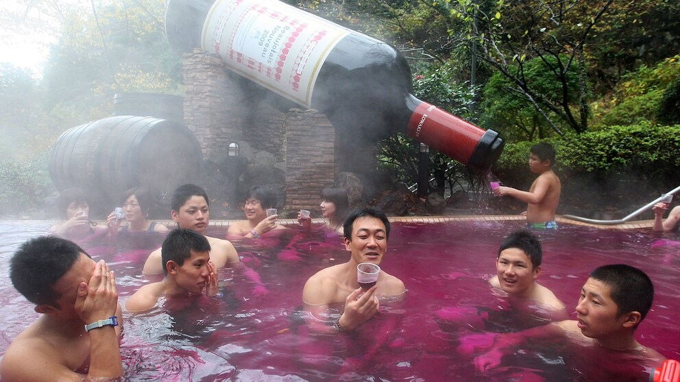 Eine angeheiterte Menschenmenge in der roten Brühe: Hier baden im japanischen Hakone Spa-Besucher in Rotwein