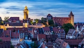 Die Kaiserburg in Nürnberg bei Dämmerung mit dem beleuchteten Sinwellturm