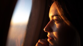 Junge Frau blickt aus dem Flugzeugfenster: Es gibt zahlreiche Mythen darüber, was man bei einer Flugbuchung alles beachten soll – eine neue Analyse hat nun einige davon widerlegt