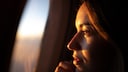 Junge Frau blickt aus dem Flugzeugfenster: Es gibt zahlreiche Mythen darüber, was man bei einer Flugbuchung alles beachten soll – eine neue Analyse hat nun einige davon widerlegt