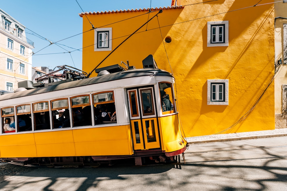 Eine der klassischen Straßenbahnen fährt durch das Alfama-Viertel