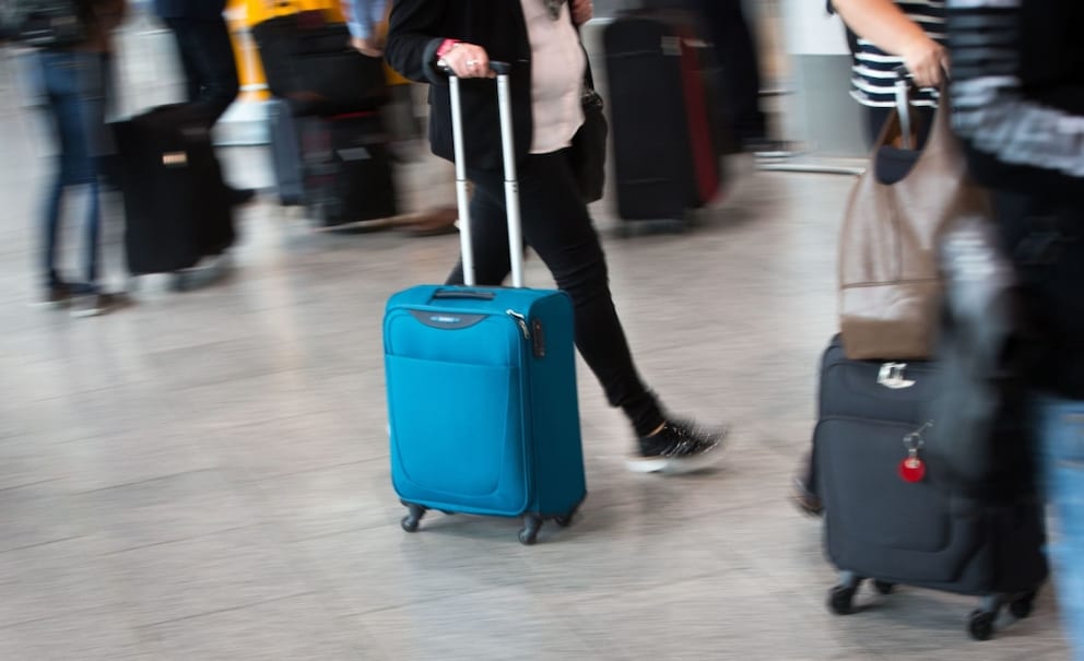 Passenger with carry-on luggage walking through the airport in Frankfurt