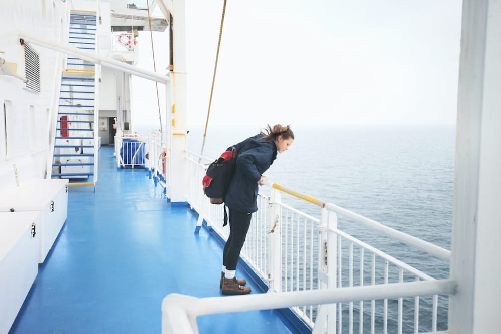 Woman looking over railing on cruise ship