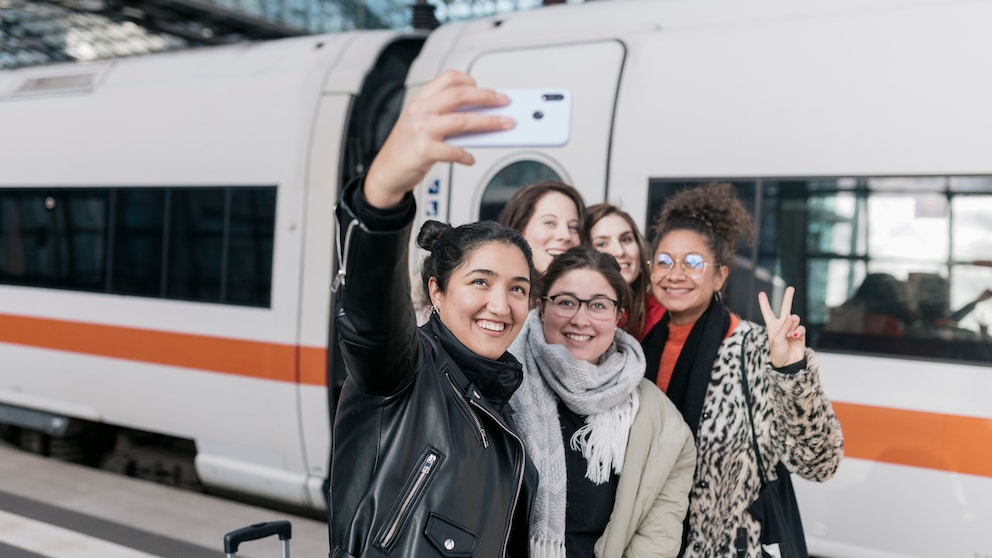 Freundinnen mit Smartphone vor einem ICE