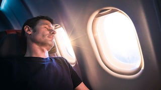 Schlafender Mann im Flugzeug: Mit unseren Tipps können Sie Ihrer nächsten Flugreise entspannt entgegenblicken