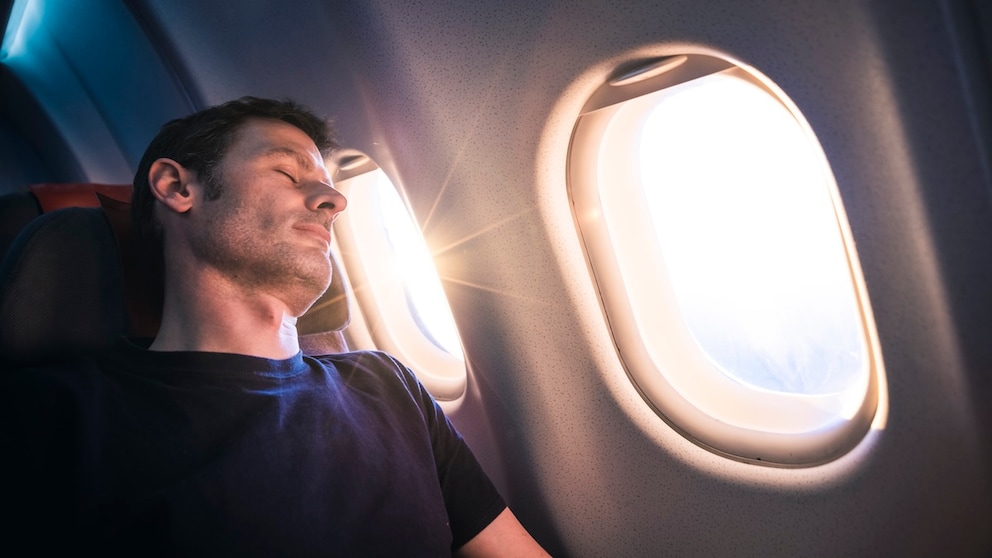 Schlafender Mann im Flugzeug: Mit unseren Tipps können Sie Ihrer nächsten Flugreise entspannt entgegenblicken