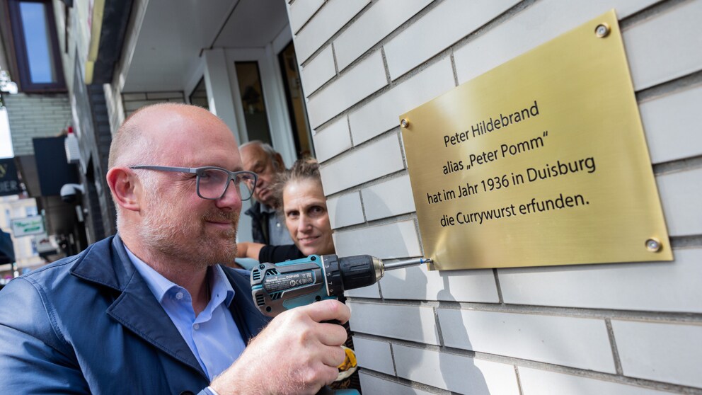 Mayor of Duisburg, Sören Link (SPD), awards a plaque to Peter Pomm's 'Pusztetten-Stube' in honor of the currywurst invention