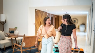 Frauen freuen sich im Hotel über Extras, die sie kostenlos erhalten ahben