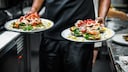 Mann mit zwei Tellern im Restaurant