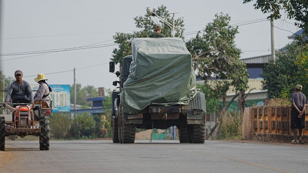 Kambodschanisches Militärfahrzeug an Traktor Evakuierter vorbei