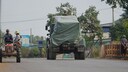 Kambodschanisches Milit&auml;rfahrzeug an Traktor Evakuierter vorbei