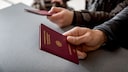 Zwei Personen pr&auml;sentieren ihre Reisep&auml;sse am Flughafen