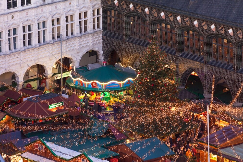 Market stalls and a carousel in front of the Lübeck Town Hall
