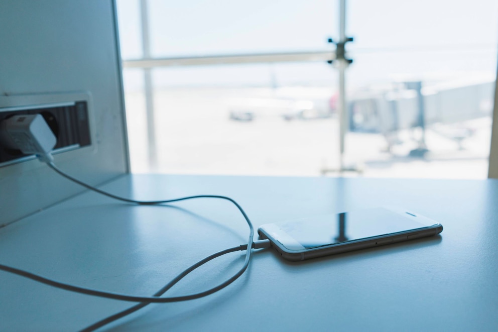 Ein Smartphone l&auml;dt an einem Flughafen