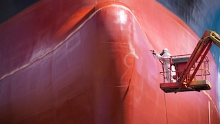 Mann vor rotem Schiff