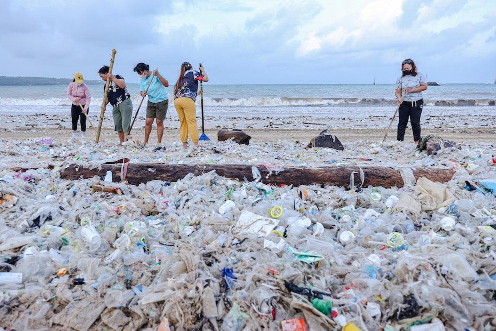 Balinese people cleaning Kedonganan Beach of trash