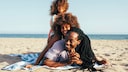 Eine Familie liegt am Strand