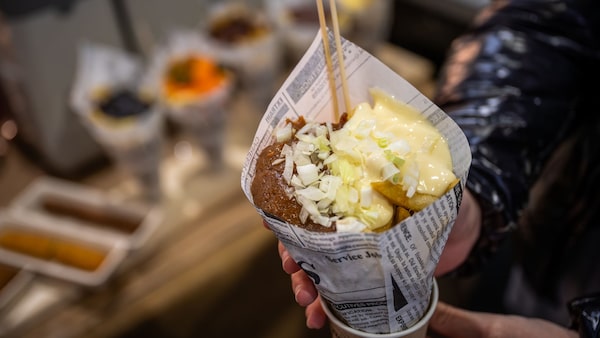 Eine Messebesucherin hält eine Tüte Pommes in der Hand