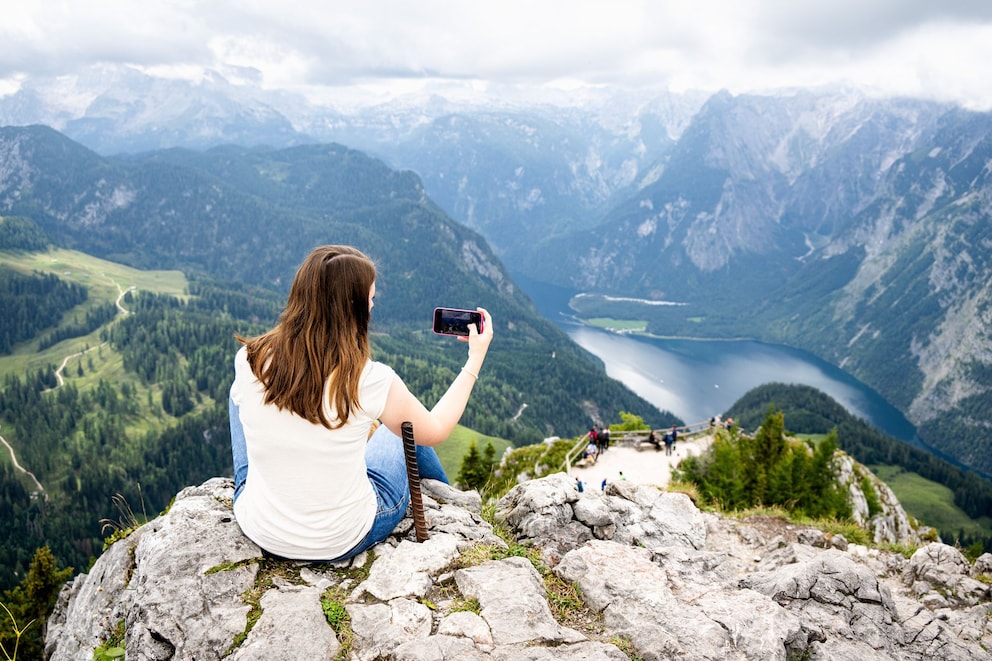 Woman photographing Königssee from the summit of Jenner