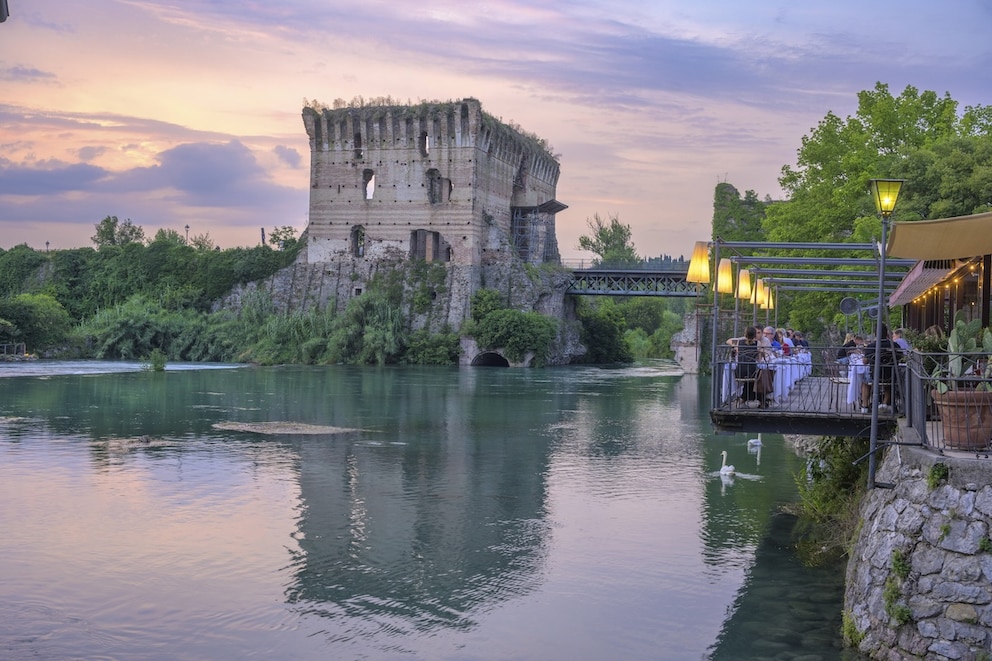 Blick auf ein Restaurant am Fluss Mincio und die Visconti-Br&uuml;cke aus dem Jahre 1395
