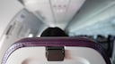 Passagierin mit zur&uuml;ckgestellter R&uuml;ckenlehne im Flugzeug