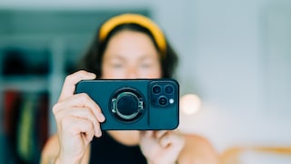 Frau beim Fotografieren ihrer Wohnung vor einer Reise